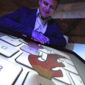 <span class=heading><b>Explorathon</b></span><br /><p class=int> </p>
<p class=int>Mark Shephard with his image "Flaming Keyboards" on the touchscreen.</p>
<p class=int> </p><span class=small>Image: © 2015 Guy Hinks</span>