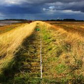 <span class=heading><b>Clouds of Change</b> by Marcin Zielinkski (Department of Civil & Environmental Engineering)</span><br /><p class=int>The picture presents the flood embankment located along river Humber in North-East of England, East Airshire. It was taken during geophysical survey which was looking at the desiccation crack detection in flood protection structures. The picture shows the perfect match between the dramatic dark clouds which are the source of rain causing flooding, and the shiny embankment which protects against flooding. Will embankments protect us ?</p><span class=small>Image: © 2012 Marcin Zielinkski</span>